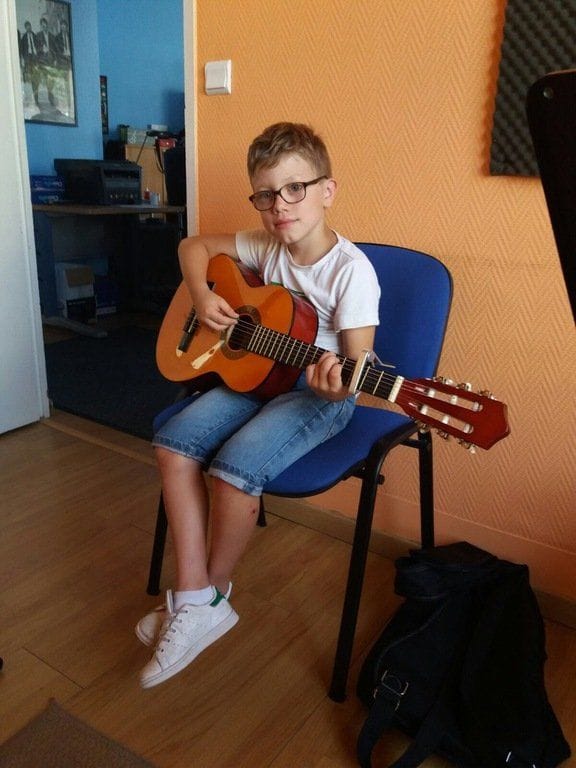 Un jeune élève de l’École Art et Musique joue de la guitare classique.