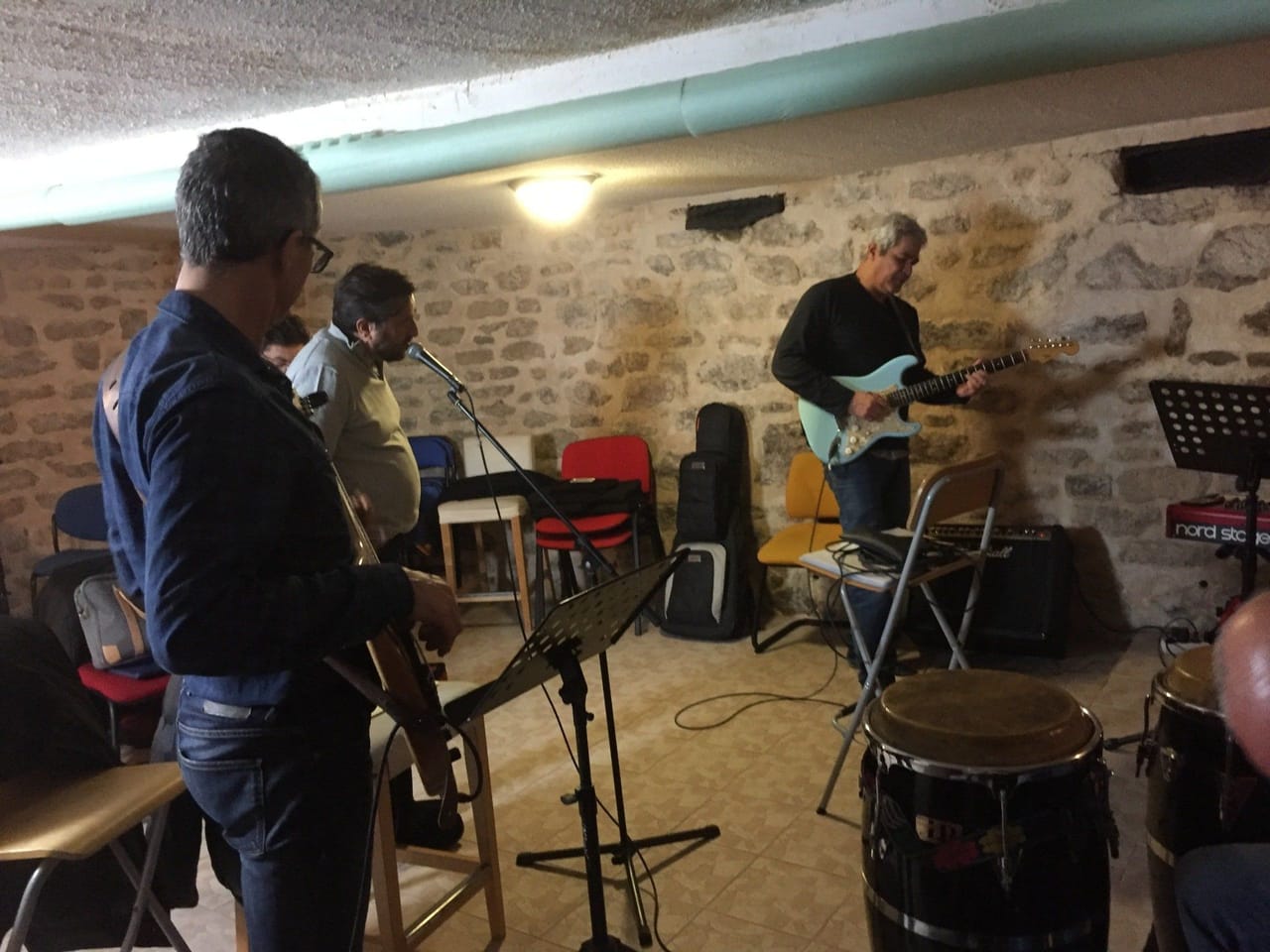 Répétition d’un groupe : batterie et basse dans la salle en pierre.